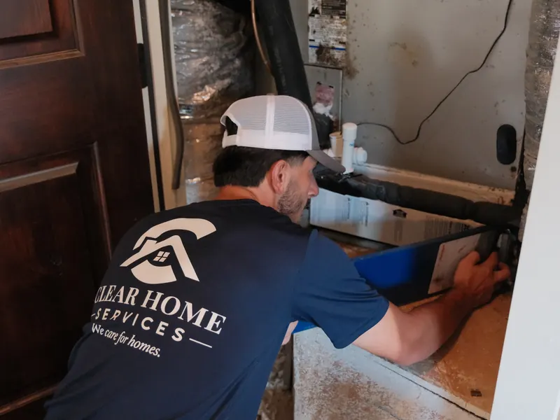 Technician installing a new HVAC air filter in a home air handler